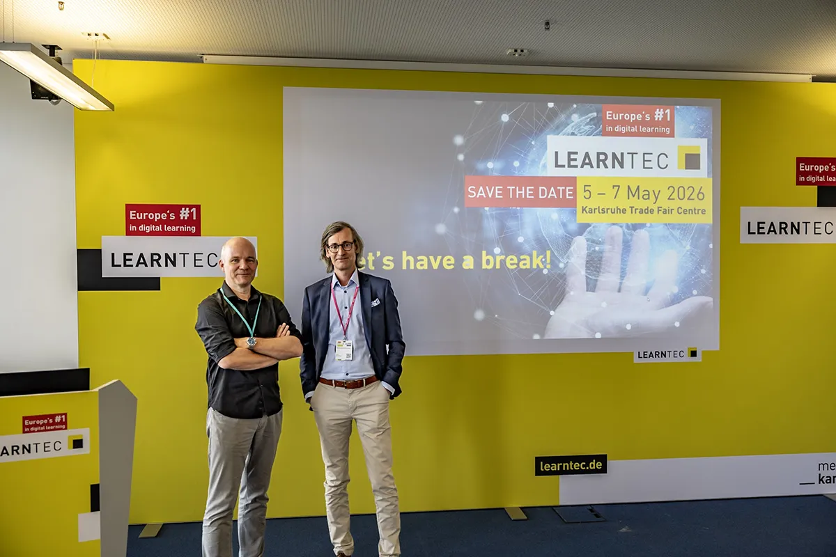 Foto von Dr. Daniel Stoller-Schai und Sven Kohlmeier vor eine gelben Wand in einem Raum des Digital Education Institute.